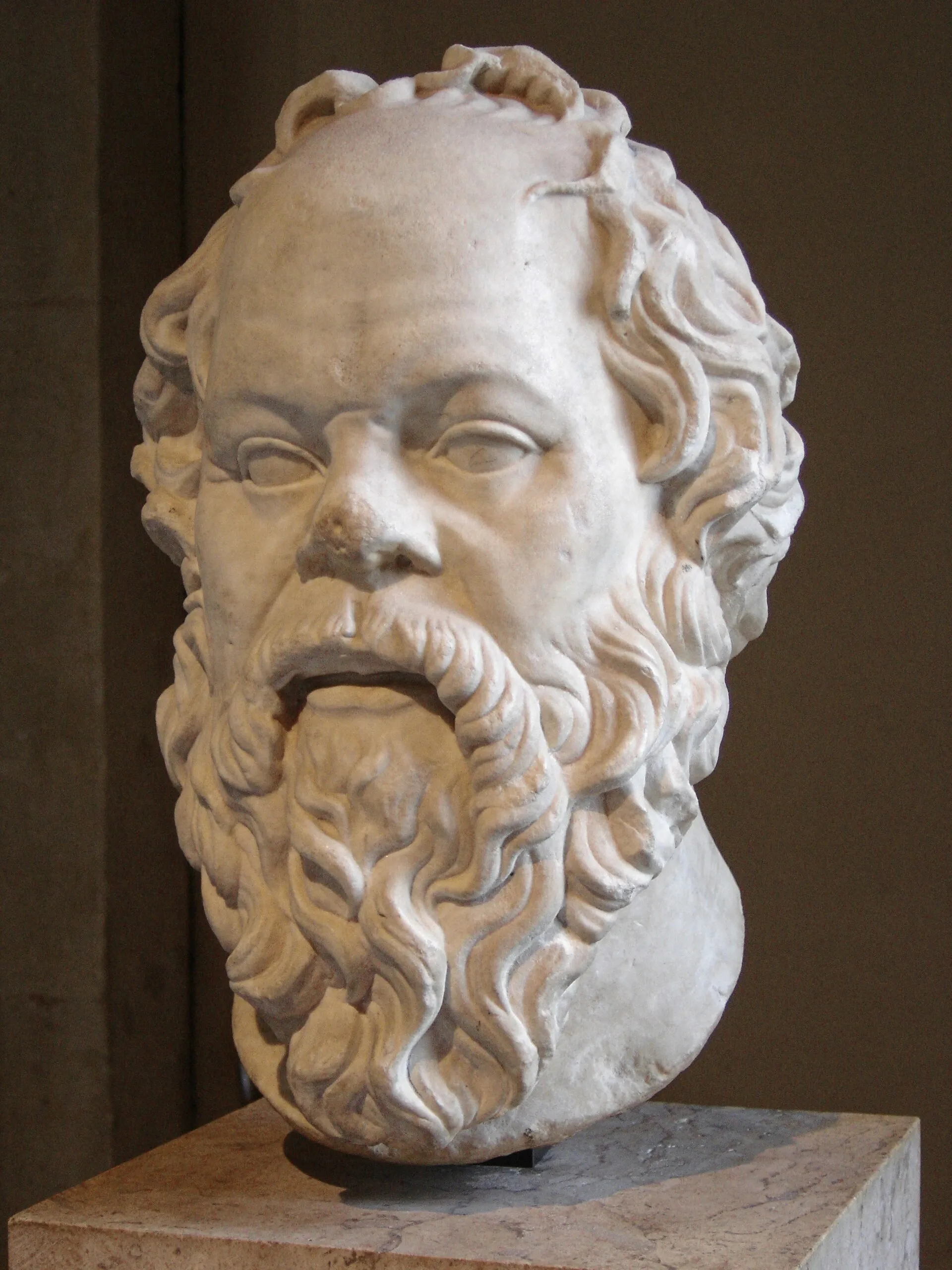 Busto de mármol de Sócrates, con barba abundante y cabeza levemente inclinada.